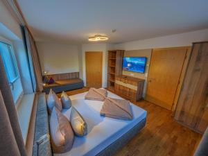 a room with a bed with pillows and a television at Ferienwohnungen Egger in Tux