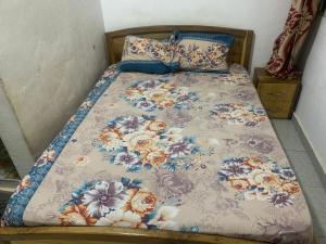 a bed with a floral comforter on it at Martino Guest House in Pokuase +10 photos