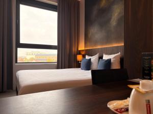 a hotel room with a bed and a window at Hotel Elisabeth in Mechelen