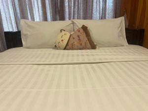 a bed with white sheets and pillows at Siri Lagoona Resort in Nong Prue +66 photos
