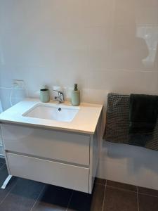 a bathroom with a white sink with two green containers on it at Neeri Home in Neerim South +27 photos