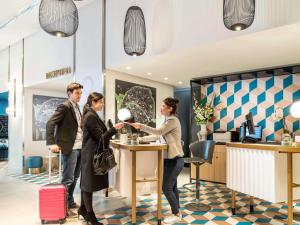 a group of people shaking hands in a hotel lobby at Aparthotel Adagio Paris Centre Tour Eiffel in Paris
