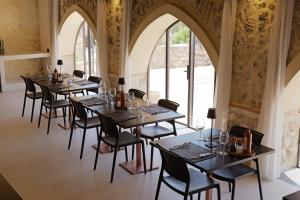a row of tables in a room with windows at Agriturismo Baglio Làuria in Campobello di Licata