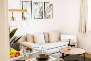a living room with a white couch and a table at Wohlfühlapartment, Parkplatz, Boxspringbetten, Massagesessel, Nespresso, 1Gbit LAN & WIFI, Innenstadt in Wolfsburg