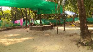 a playground with a hammock and a tree at Sai Homestay Tarkarli in Malvan