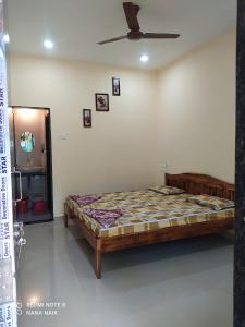 a bedroom with a bed and a ceiling fan at Sai Homestay Tarkarli in Malvan