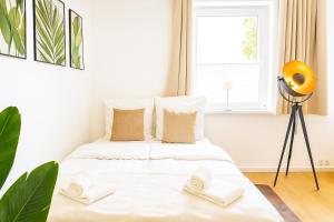 a bedroom with a bed with white sheets and a window at Wohlfühlapartment, Parkplatz, Boxspringbetten, Massagesessel, Nespresso, 1Gbit LAN & WIFI, Innenstadt in Wolfsburg +31 photos