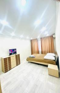 a bedroom with a bed and a tv in it at City in Uralsk