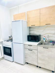 a kitchen with a white refrigerator and a sink at City in Uralsk