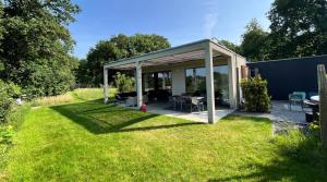 a pavilion with a table and chairs in a yard at Verblijf Glunder in Lemele