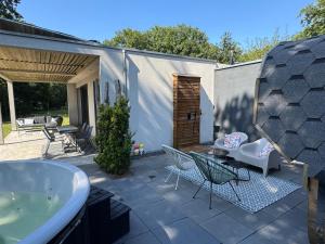 a patio with a tub and a table and chairs at Verblijf Glunder in Lemele