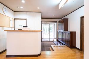 a kitchen with white cabinets and a counter at ホテル白馬五竜ベース in Hakuba