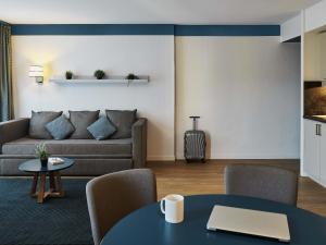 a living room with a couch and a table at Aparthotel Adagio Monaco Palais Joséphine in Beausoleil +60 photos
