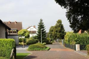 a residential street with houses and trees and a driveway at Beautiful 3-room apartment in Lohmar in Lohmar