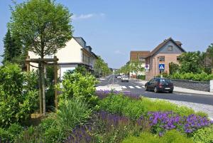 a street in a small town with purple flowers at Beautiful 3-room apartment in Lohmar in Lohmar