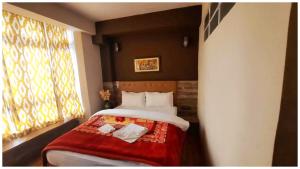 a bedroom with a bed with a red blanket at Hotel The OIive Premium Near Gurudwara Guru Nanak Darbar- Valley Mountain View - Wifi - Room Service Available - A Premium Hotel In Darjeeling in Darjeeling
