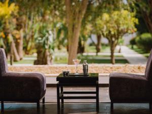 two chairs and a coffee table with a drink on it at Sofitel Rabat Jardin Des Roses in Rabat