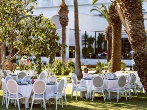 un grupo de mesas con sillas blancas y palmeras en Sofitel Rabat Jardin Des Roses, en Rabat 168 fotos más