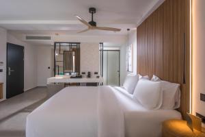 a bedroom with a large white bed and a bathroom at Noble Hotel & Suites - Adults Only in Gouves