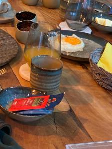 a table with a plate of eggs and a glass of juice at Si brugge in Bruges