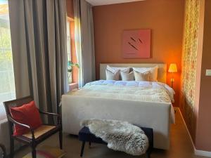 Un dormitorio con una cama, una silla y una ventana en Si brugge, en Brujas