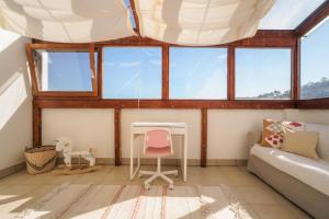 a room with windows and a couch and a desk at Eco Casa Branca in nature in Aljezur +61 photos