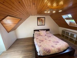 a bedroom with a large bed in a attic at Charmante maison de campagne in Commana