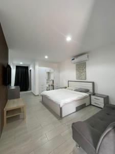 a white bedroom with a bed and a couch at EK Homes in Ras al Khaimah