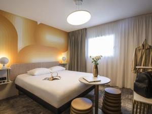 Ένα ή περισσότερα κρεβάτια σε δωμάτιο στο ibis Styles Pertuis Portes du Luberon
