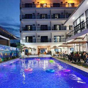 a swimming pool with a hotel in the background at Ocean Star Hotel Coron in Coron