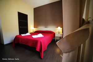 1 dormitorio con 1 cama roja y 2 toallas en Rome Vatican Suite, en Roma