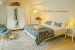 Un dormitorio con una cama y una silla azul. en Les oiseaux de passage - chambre d hôtes, paisible, en Gaillon