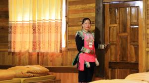 a woman is standing in front of a door at Homstay Páo Ấm Mai in Tát Lá