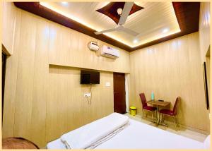 a hospital room with a bed and a table with chairs at LUXUARY HOTEL - THE D!A - Nest - Primium - Near The Holy Kashi Vishwanath Temple !! # Free Wi-Fi Facilities - Fully Air Conditioned Hotel in Pricious location - Best Hotel In Varanasi in Rāmnagar
