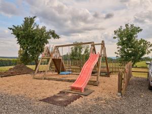 ÚhlejovにあるHoliday Home Růžovka by Interhomeの土の上に赤い滑り台がある遊び場