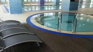a large swimming pool in a building with chairs at 팔레드시즈 콘도- Pale de CZ Condo in Busan