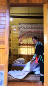 a woman is standing on a bunk bed at Homstay Páo Ấm Mai in Tát Lá