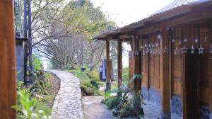 a stone path next to a house with a building at Homstay Páo Ấm Mai in Tát Lá +11 photos