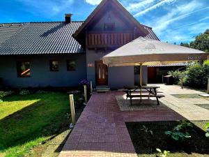 a picnic table with an umbrella in front of a house at Apartmán U Vachtů - První Patro in Kubova Huť +5 photos