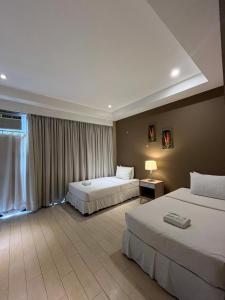 a hotel room with two beds and a window at Villa Verde Guest House in General Santos