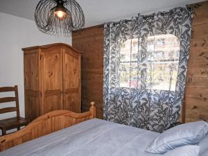 a bedroom with a bed and a window with a curtain at Apartment Ardève No 11 by Interhome in Ovronnaz
