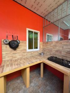 - une cuisine avec des murs orange et un comptoir en bois dans l'établissement Aonang Private House, à Ao Nang Beach
