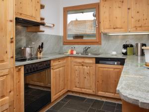 a kitchen with wooden cabinets and a sink at Apartment Chesa Vadret 12 by Interhome in Pontresina