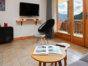a living room with a book on a coffee table at Apartment Les Chalets de Marie A 22 by Interhome in Ovronnaz