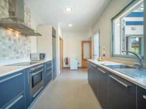 eine Küche mit blauen Schränken, einem Waschbecken und einem Fenster in der Unterkunft Villa Amanecer by Interhome in Alcúdia + 21 Fotos