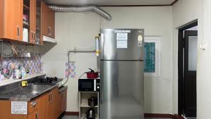 une cuisine avec un réfrigérateur en acier inoxydable dans l'établissement Young Place, à Songt'an 12 autres photos
