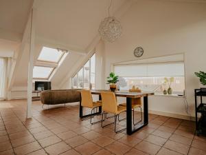 a living room with a table and chairs and a couch at Apartment Penthouse by Interhome in Uitgeest +16 photos