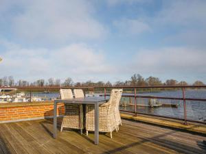 a table and chairs on a deck overlooking a body of water at Apartment Penthouse by Interhome in Uitgeest