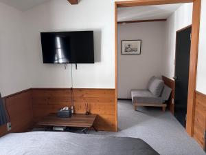 a bedroom with a bed and a television on the wall at Shika Lodge in Iiyama