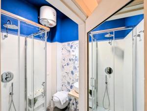 a bathroom with a shower with blue walls at Incoming Quartieri Spagnoli in Naples